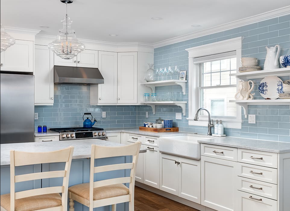 A kitchen with blue walls and white cabinets.