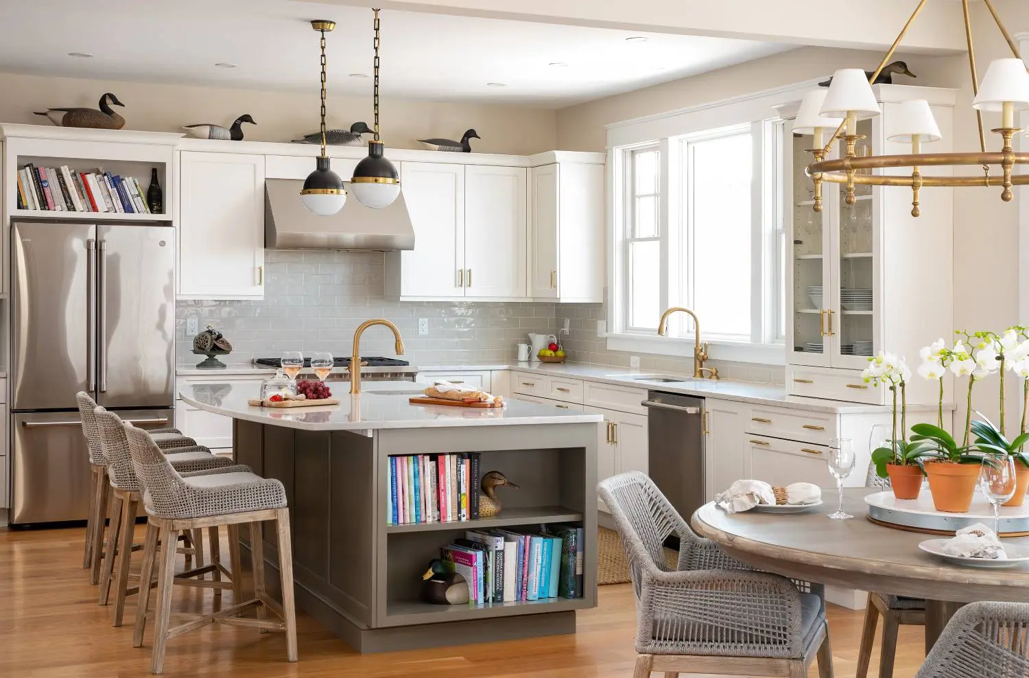 A kitchen with white cabinets and wooden floors.