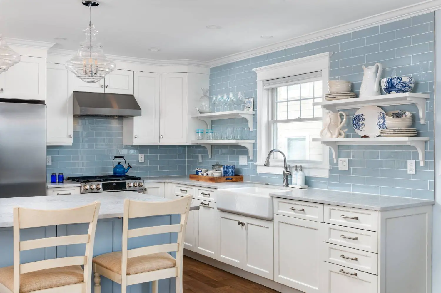 A kitchen with blue walls and white cabinets.