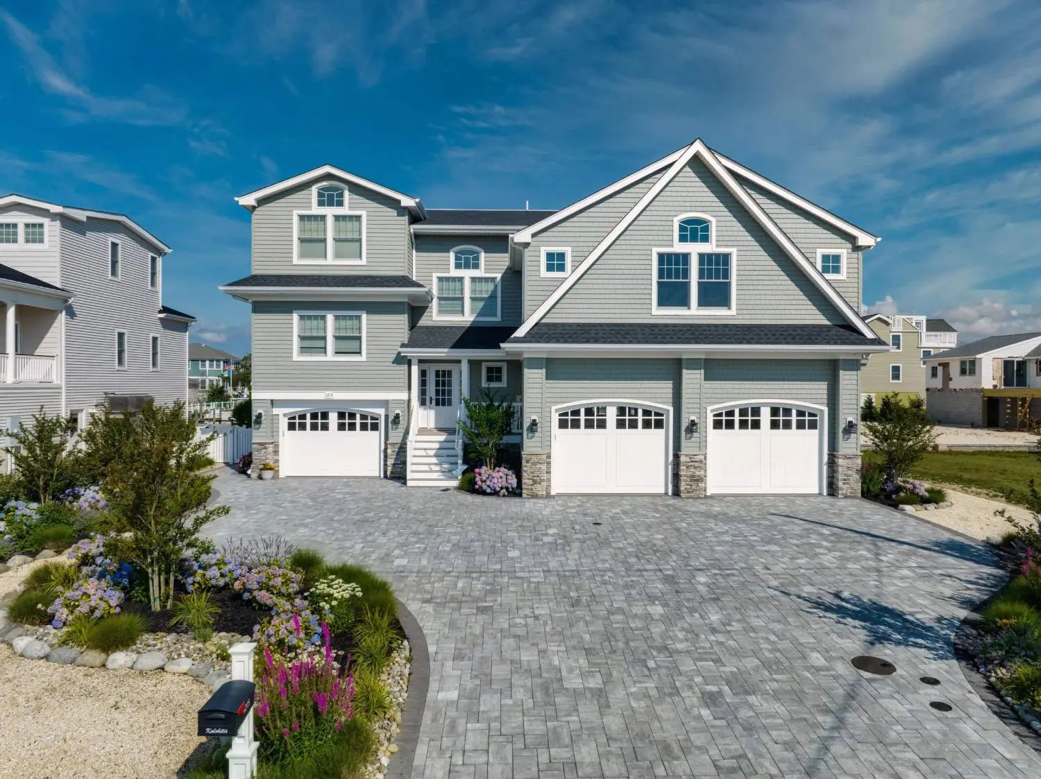 A large house with two garage doors and a driveway.