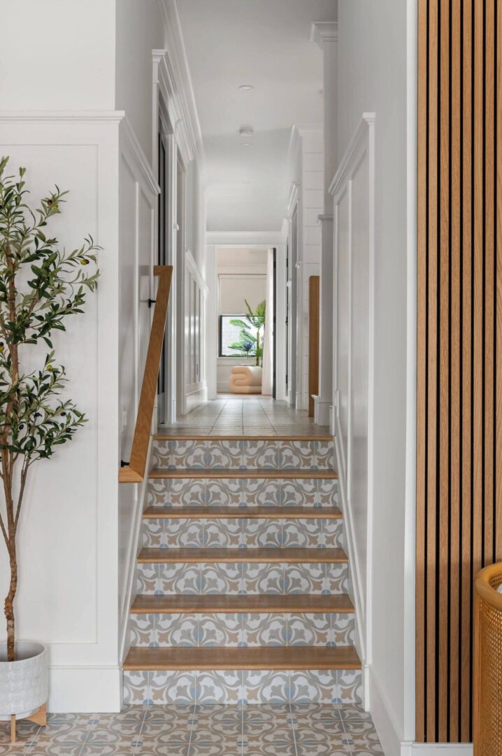 A hallway with stairs and a tree in the middle.