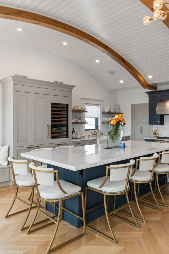 A large kitchen with white cabinets and blue island.