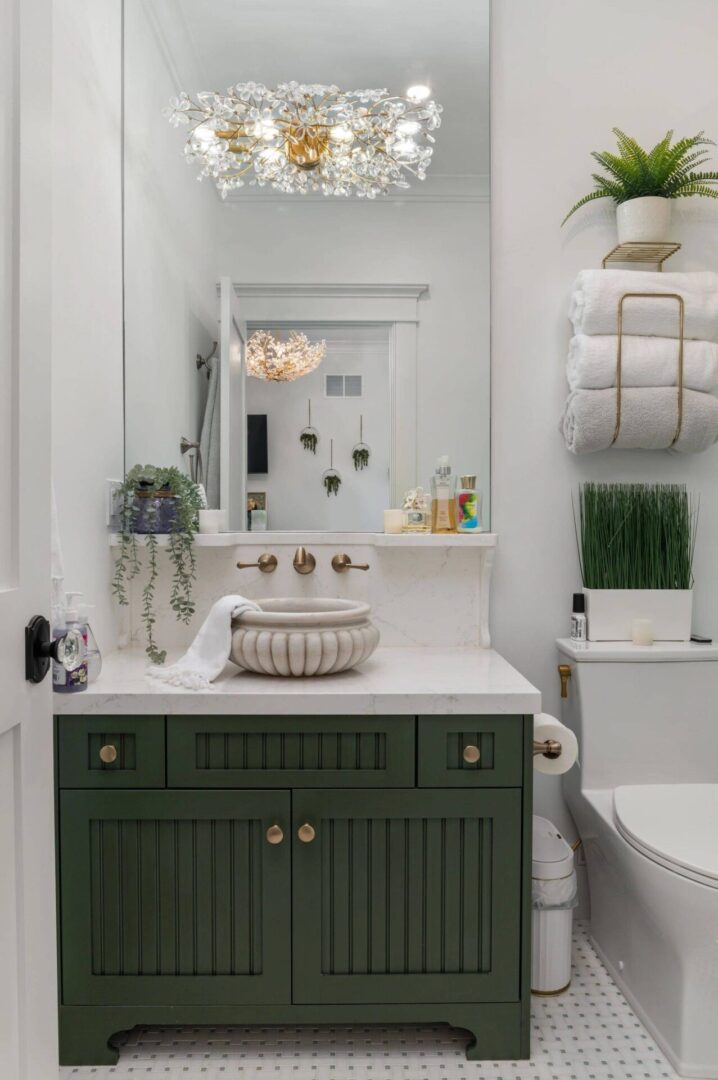 A bathroom with green cabinets and white walls.