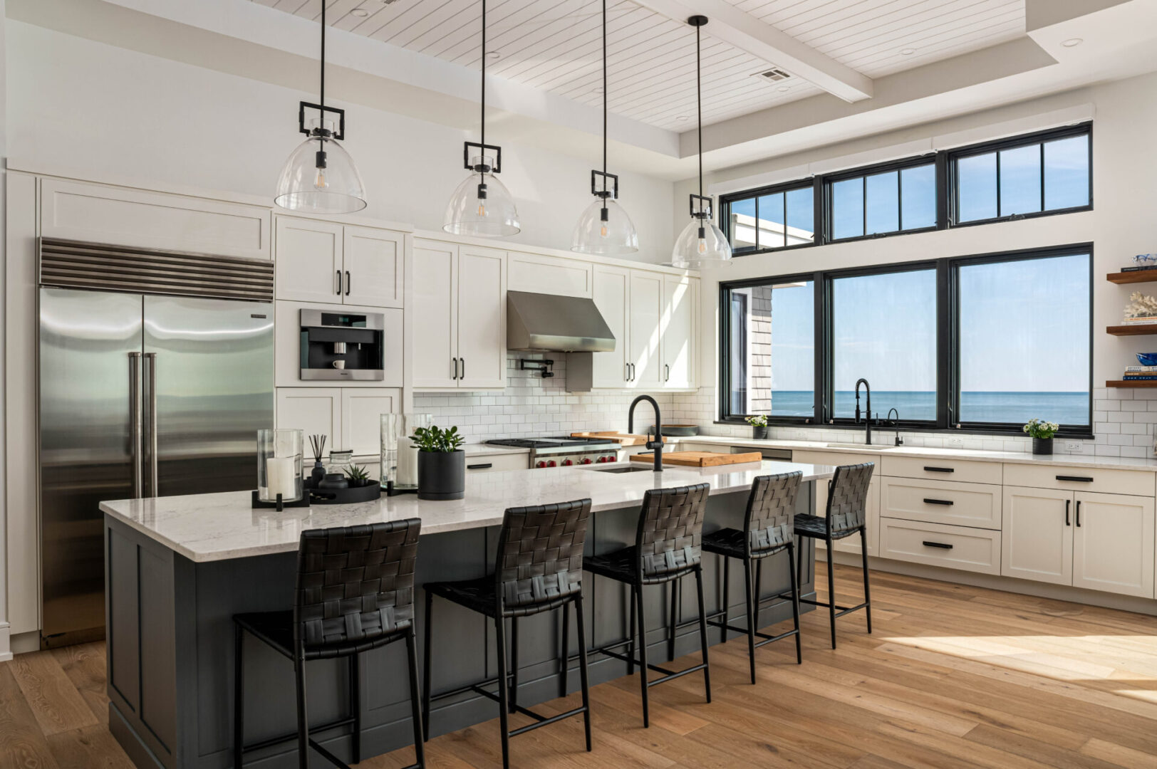 A large kitchen with lots of counter space and hanging lights.