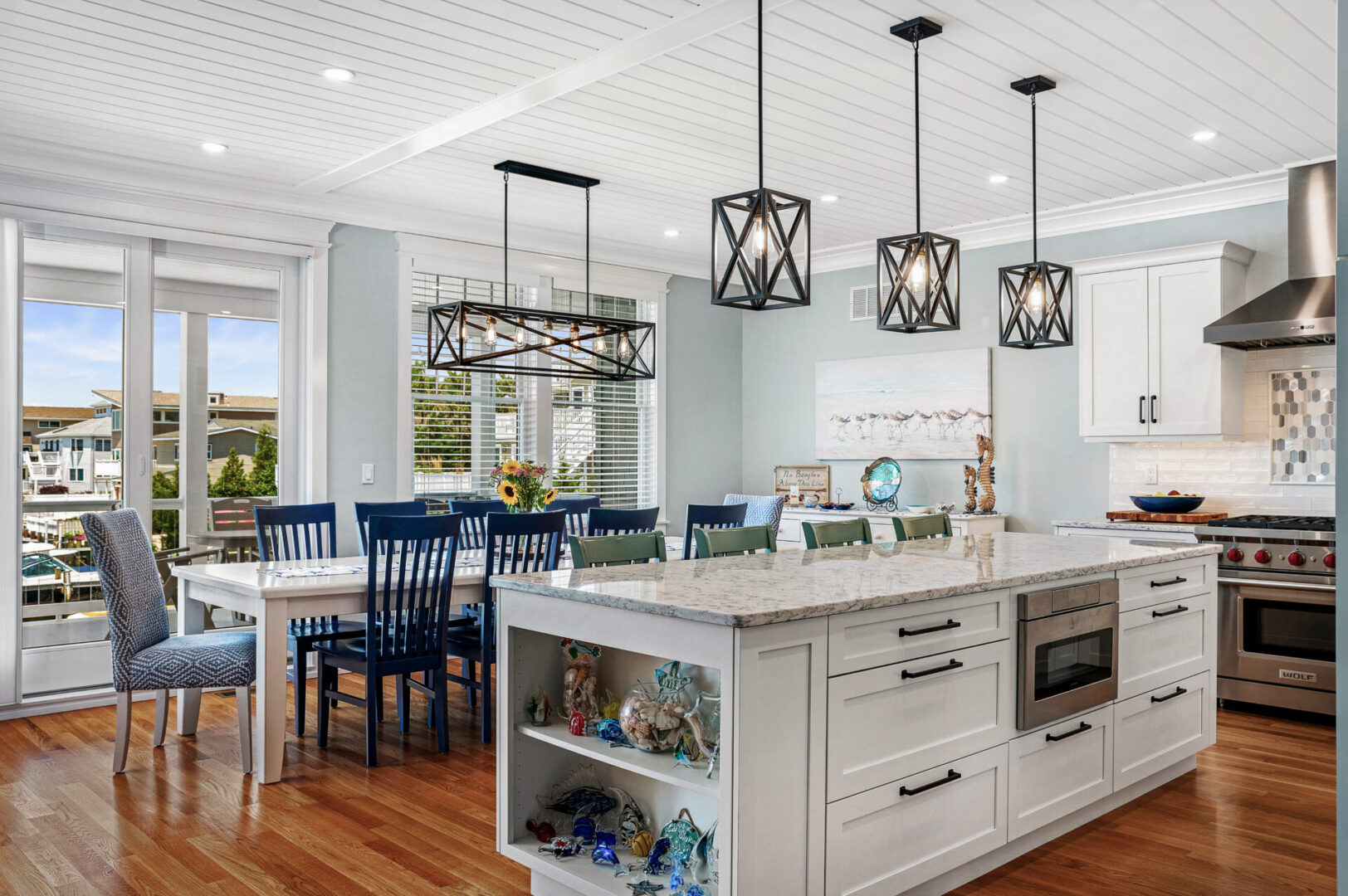 A kitchen with white cabinets and blue chairs