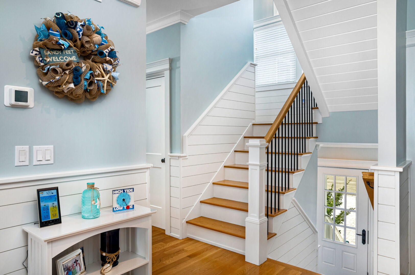 A white staircase with wooden steps and metal railing.