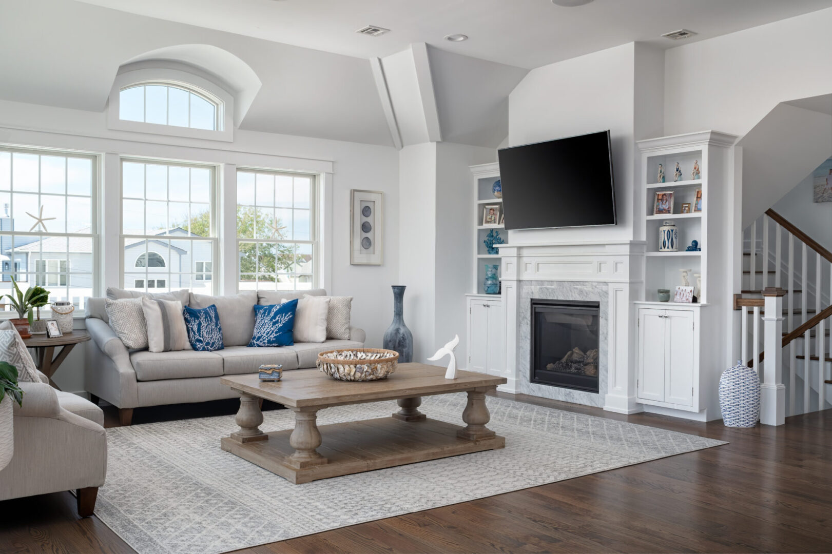 A living room with a couch, fireplace and television.