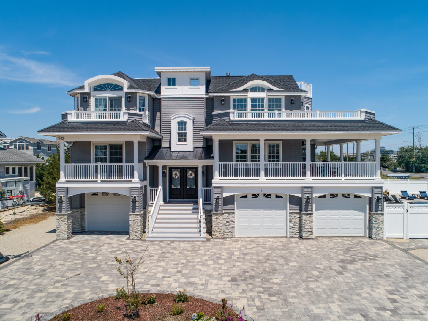 A large white house with two garage doors.