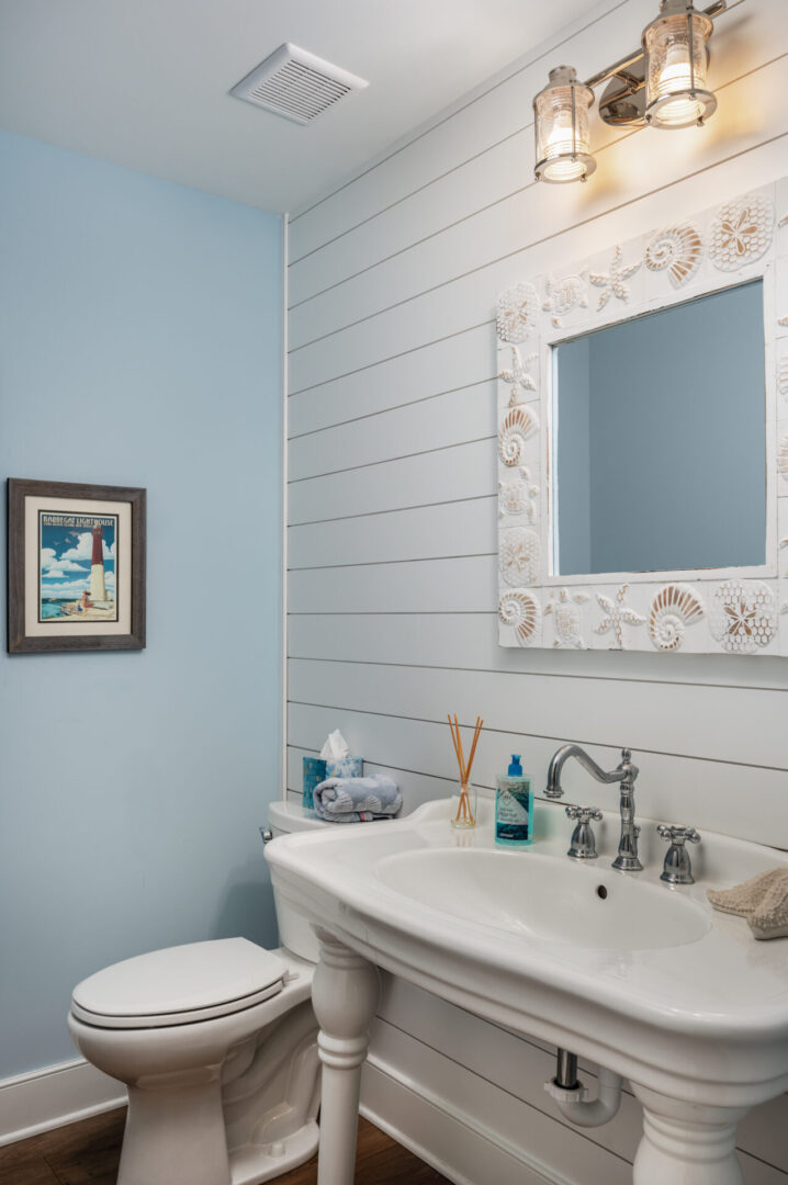 A bathroom with a sink, mirror and toilet.