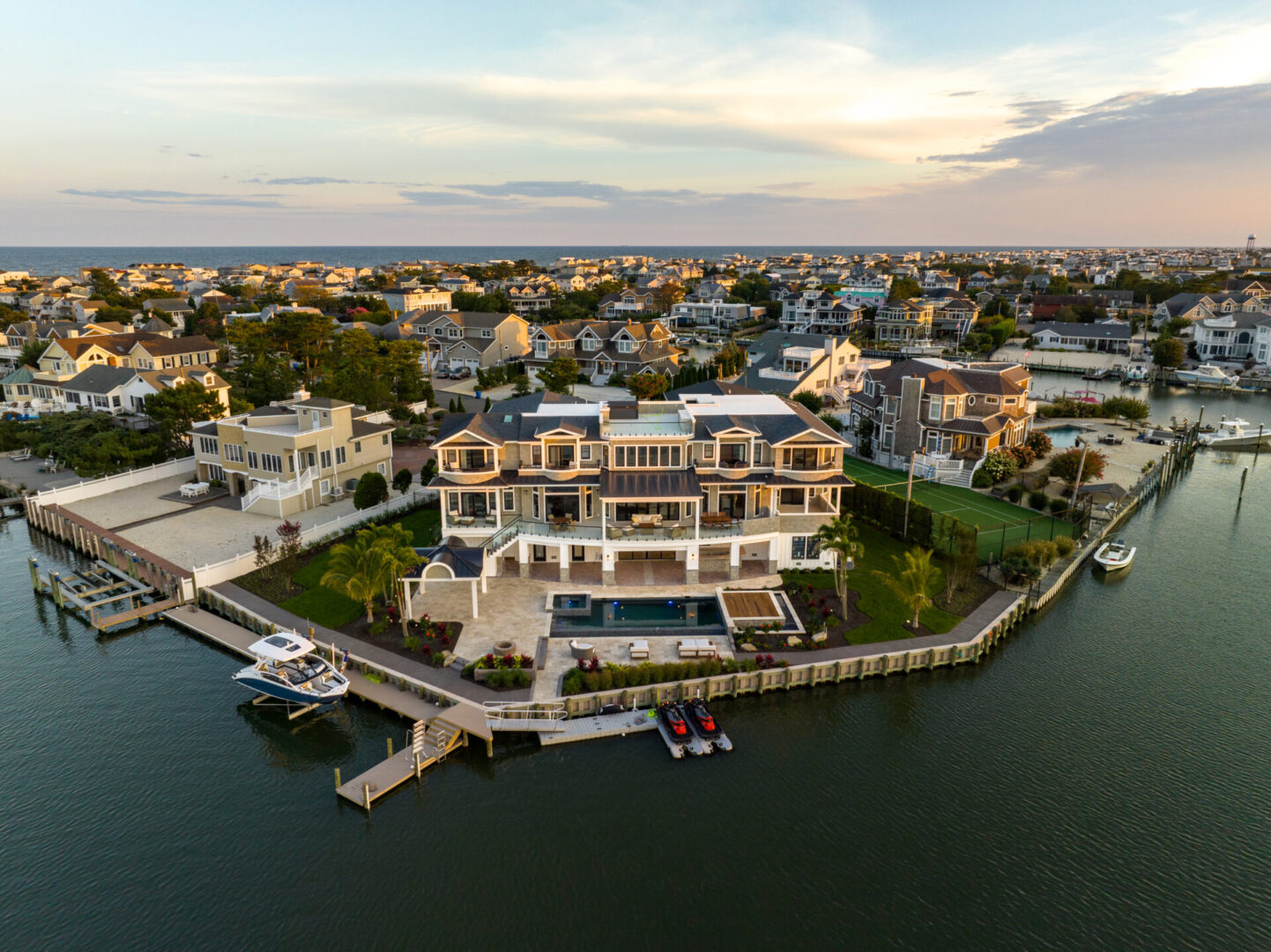 A large house on the water with a dock in front of it.