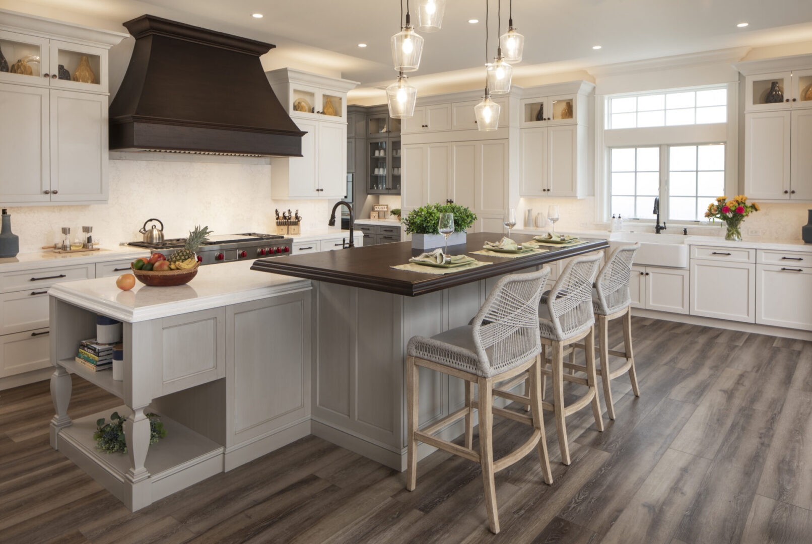 A kitchen with white cabinets and wooden floors.